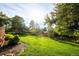 Spacious, lush green backyard features manicured lawn and mature trees at 41 Skyline Dr, Wheat Ridge, CO 80215