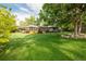 Large backyard features a wood deck, mature trees, and a hammock for relaxation at 41 Skyline Dr, Wheat Ridge, CO 80215