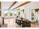 Open concept living area featuring exposed beams, a white brick fireplace, and large windows at 41 Skyline Dr, Wheat Ridge, CO 80215