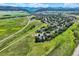 Picturesque aerial view of homes nestled among rolling hills, lush green fields, and majestic mountains at 8915 S Field Ct, Littleton, CO 80128