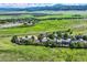 Breathtaking aerial view of homes surrounded by lush green fields and mountains in the distance at 8915 S Field Ct, Littleton, CO 80128