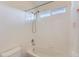 Bright bathroom with a tub/shower combination featuring white tiles and a window for natural light at 8915 S Field Ct, Littleton, CO 80128