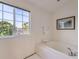 Well-lit bathroom featuring a soaking tub and a window at 8915 S Field Ct, Littleton, CO 80128