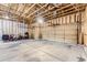 Spacious garage featuring exposed wood beams, concrete flooring, and ample space for storage and parking at 8915 S Field Ct, Littleton, CO 80128