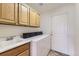 Well-equipped laundry room features ample cabinetry, a utility sink, and a modern washer and dryer set at 8915 S Field Ct, Littleton, CO 80128
