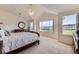 Bright primary bedroom featuring high ceilings, large windows, and scenic views at 8915 S Field Ct, Littleton, CO 80128