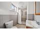 Bathroom with a shower, toilet, sink, and window at 12024 W Maryland Dr, Lakewood, CO 80228