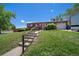 A home with a brick facade and a well-manicured lawn accessible by a stairway, all on a sunny day at 12024 W Maryland Dr, Lakewood, CO 80228
