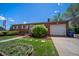 Classic brick home with attached garage, verdant lawn, and tidy landscaping presents a welcoming curb appeal at 12024 W Maryland Dr, Lakewood, CO 80228