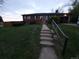 Cozy brick home featuring a sloped front yard with a concrete staircase and a black metal handrail at 12024 W Maryland Dr, Lakewood, CO 80228