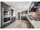 Kitchen featuring stainless steel appliances, modern cabinetry, brick backsplash and wood flooring at 12024 W Maryland Dr, Lakewood, CO 80228