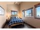 Comfortable bedroom with wood-trimmed windows offering scenic views and stylish decor at 18645 Rocky Top Trl, Littleton, CO 80127