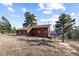 Exterior image featuring a wood-sided house with a deck nestled amidst trees and panoramic views at 18645 Rocky Top Trl, Littleton, CO 80127