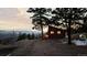 Charming log cabin with warm interior lights, surrounded by trees and mountain views at 18645 Rocky Top Trl, Littleton, CO 80127