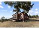 Inviting log cabin-style home featuring a spacious deck and mature trees on a picturesque landscape at 18645 Rocky Top Trl, Littleton, CO 80127