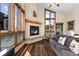 Bright living room with a fireplace, large windows with mountain views, and a striped rug at 18645 Rocky Top Trl, Littleton, CO 80127
