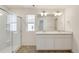 This bathroom includes double sinks, vanity lighting, and glass-enclosed shower at 262 Chardon Ave, Brighton, CO 80601