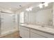 This bathroom features a shower with glass door and double sinks, lit by modern vanity lights at 262 Chardon Ave, Brighton, CO 80601