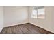 Bright bedroom features a window and sleek hardwood floors with neutral walls and white trim at 262 Chardon Ave, Brighton, CO 80601