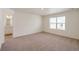 This bedroom has neutral carpet and a window, with an ensuite bathroom visible at 262 Chardon Ave, Brighton, CO 80601
