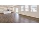 Bright, open living area with hardwood floors, white walls, kitchen, and large windows for ample natural light at 262 Chardon Ave, Brighton, CO 80601