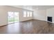 Spacious living room featuring hardwood floors, fireplace, sliding glass door to backyard, and ample light at 262 Chardon Ave, Brighton, CO 80601