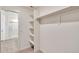 This walk-in closet boasts functional shelving, with a bathroom visible in the background at 262 Chardon Ave, Brighton, CO 80601