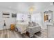 Bright bedroom featuring light walls, wood floors, decorative chandelier and mountain scene wall art at 10896 Timothys Dr, Conifer, CO 80433