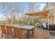 Mountain view deck with wooden dining table and seating with an overhead trellis and string lights at 10896 Timothys Dr, Conifer, CO 80433