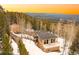Stunning mountain home boasts incredible views, mature trees, and ample privacy on a snow-covered lot at 10896 Timothys Dr, Conifer, CO 80433