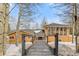 Beautiful home exterior view accessible via wooden bridge and surrounded by trees at 10896 Timothys Dr, Conifer, CO 80433