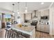 Modern kitchen with granite countertops, stainless steel appliances, a large island with barstool seating and dining area at 749 Bishop Pine Way, Castle Rock, CO 80104