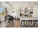 Bright kitchen area featuring a dining table, stainless steel appliances, and a granite island with bar stools at 749 Bishop Pine Way, Castle Rock, CO 80104