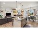 Open-concept living and dining area with a kitchen island and modern pendant lights at 749 Bishop Pine Way, Castle Rock, CO 80104