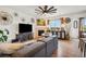 Open living room featuring a ceiling fan, stone fireplace, and modern decor at 749 Bishop Pine Way, Castle Rock, CO 80104