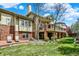 Expansive backyard with a lush lawn, mature trees, and a multi-level deck at 9164 E Lost Hill Trl, Lone Tree, CO 80124