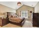 Vaulted ceiling bedroom boasts a king-sized bed with dark wood furnishings and great natural light from a large window at 9164 E Lost Hill Trl, Lone Tree, CO 80124