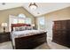 Cozy bedroom with vaulted ceiling, large windows, and stylish dark wood furniture at 9164 E Lost Hill Trl, Lone Tree, CO 80124