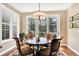 Bright dining area with hardwood floors, round table, chairs, large windows, and access to outdoor patio at 9164 E Lost Hill Trl, Lone Tree, CO 80124