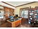 Large home office with built-in shelves, desk, hardwood floors, large windows, and good natural light at 9164 E Lost Hill Trl, Lone Tree, CO 80124