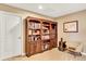 This office features custom bookshelves, a reading chair, and a neutral color scheme for a productive work environment at 9164 E Lost Hill Trl, Lone Tree, CO 80124