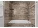 Shower and bathtub with brown marbled backsplash and tile at 2101 S Victor St # C, Aurora, CO 80014