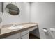 Well-lit bathroom featuring a sink with countertop space, an oval mirror, and a toilet at 2101 S Victor St # C, Aurora, CO 80014