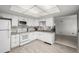 Bright, clean kitchen with white appliances, tiled floors, and an open view to the living area at 2101 S Victor St # C, Aurora, CO 80014