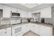 Modern kitchen features white cabinetry, an adjacent laundry room, and tiled backsplash at 2101 S Victor St # C, Aurora, CO 80014