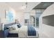 This bedroom features natural light, a blue accent wall, and an ensuite bath at 891 14Th St # 1506, Denver, CO 80202