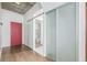 Hallway with a red door, sliding frosted glass doors, and wood floors at 891 14Th St # 1506, Denver, CO 80202