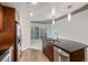 Sleek, modern kitchen with stainless steel dishwasher, dark counters, and view to living area at 891 14Th St # 1506, Denver, CO 80202