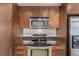 Well-equipped kitchen featuring stainless appliances, dark counters, and ample wood cabinetry at 891 14Th St # 1506, Denver, CO 80202