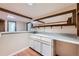 Basement bar with white cabinets, countertop sink, wood trim, and mirrored decor above the counter at 2446 S Vaughn Way # A, Aurora, CO 80014